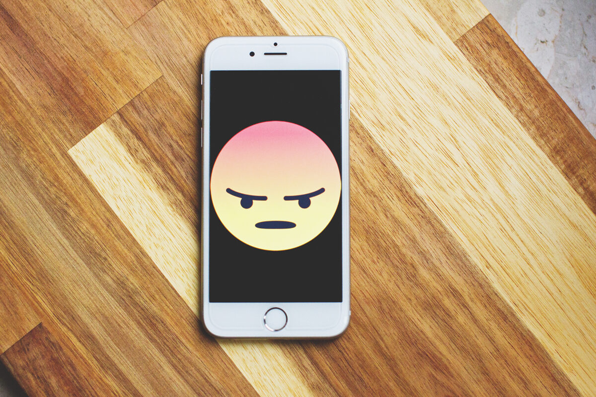 Angry face emoji on phone screen
